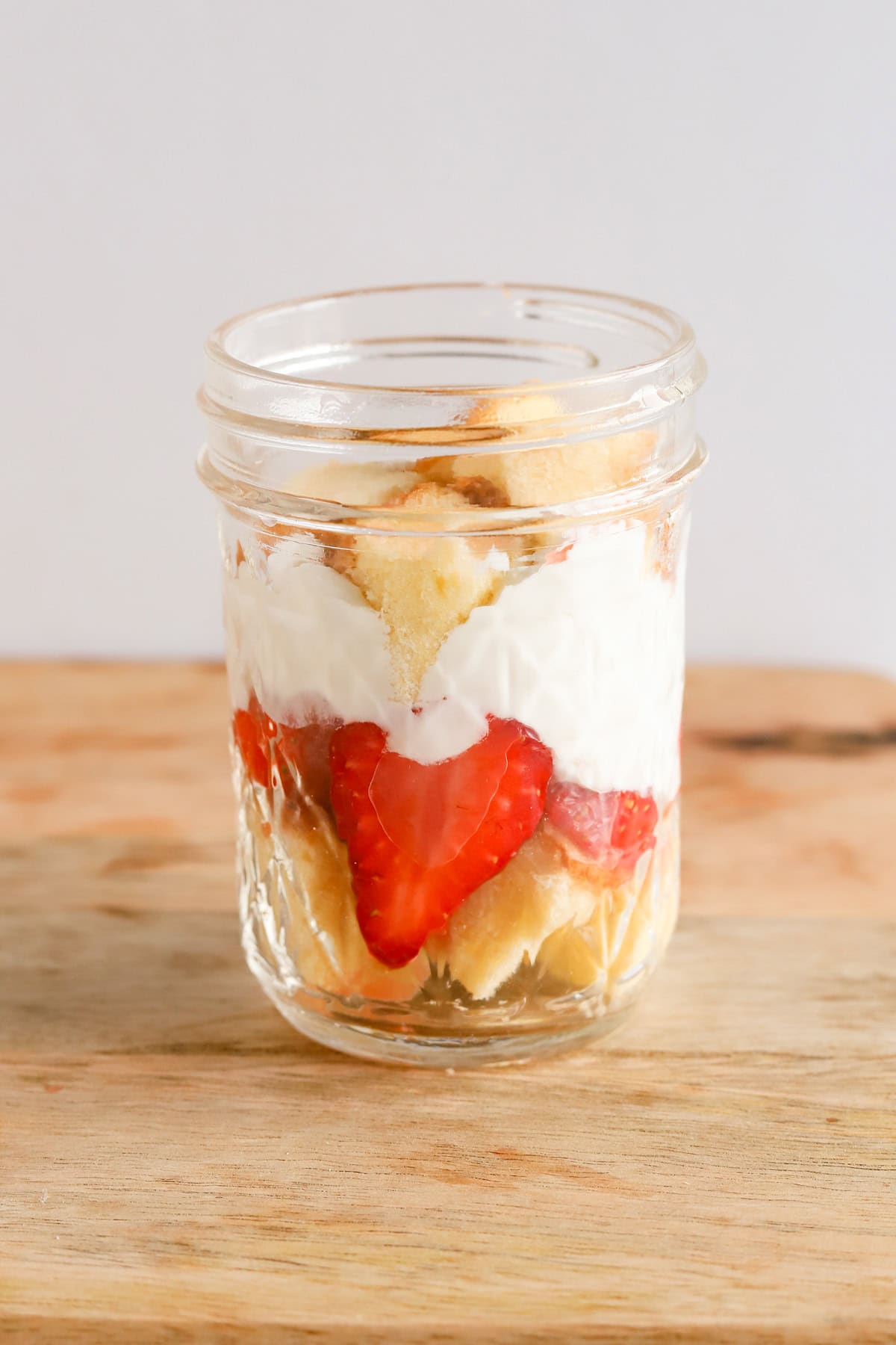 Second layer of pound cake on top of whipped cream and strawberries