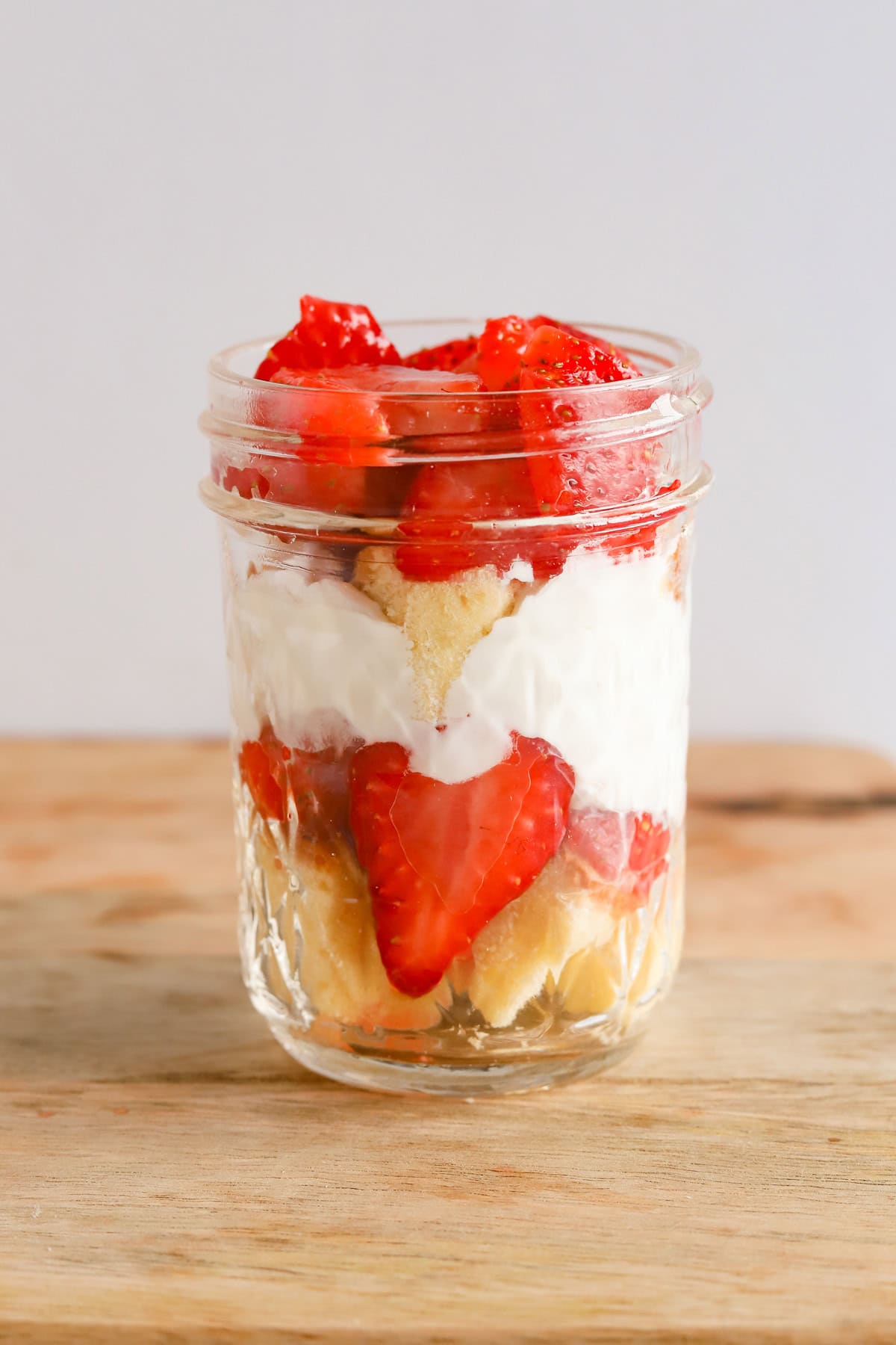 Second layer of strawberries filling the mason jar.
