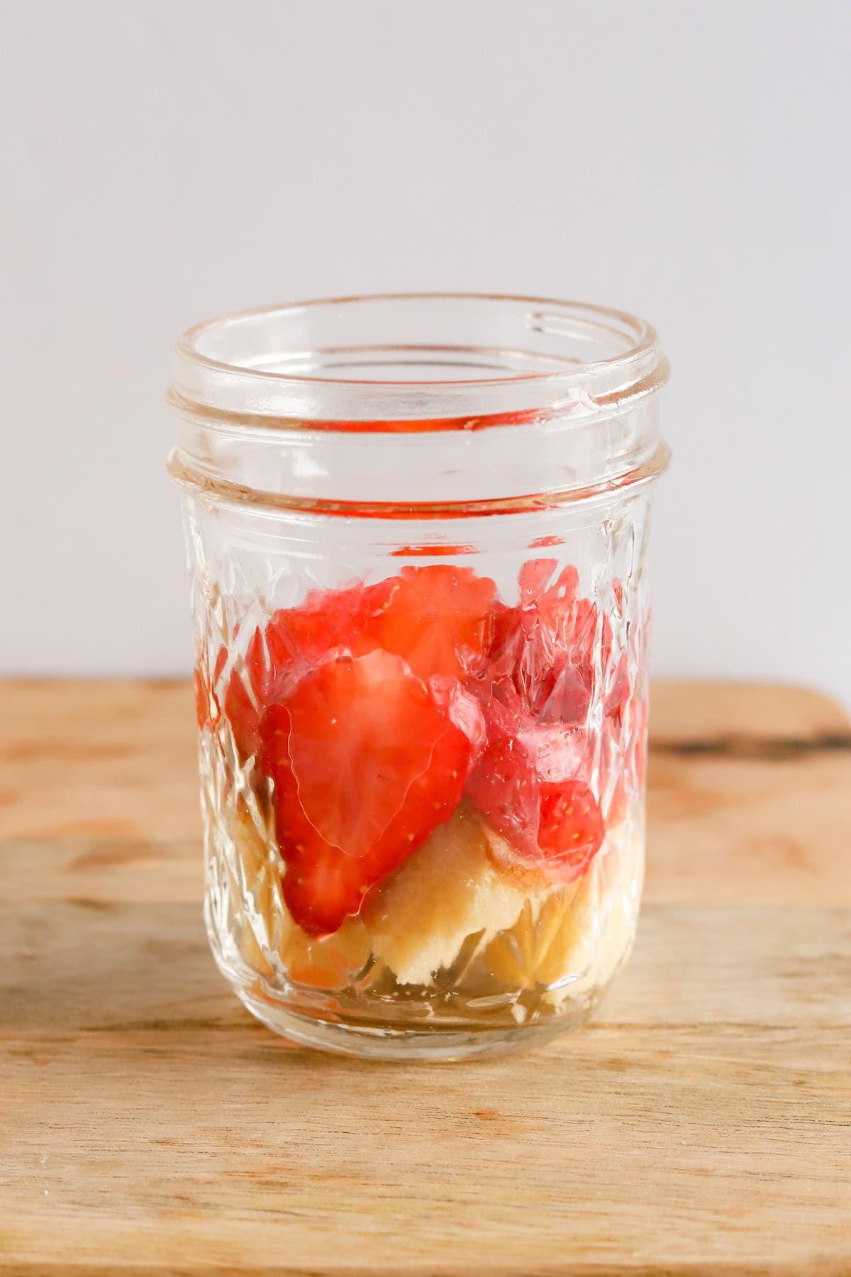 Pound cake cubes and sliced strawberries in a mason jar.