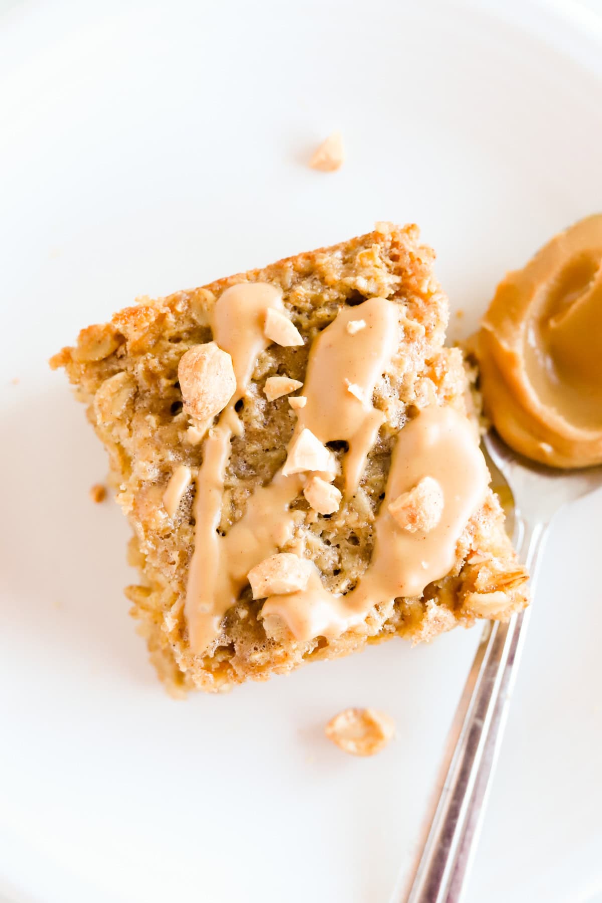 Close up of a square of peanut butter baked oatmeal with more peanut butter drizzled on top.