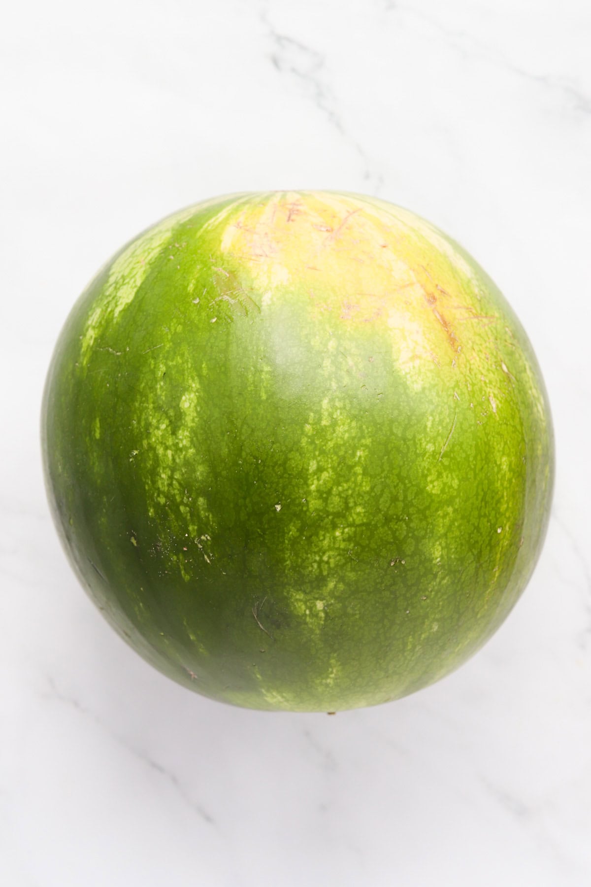 Whole round watermelon on counter.