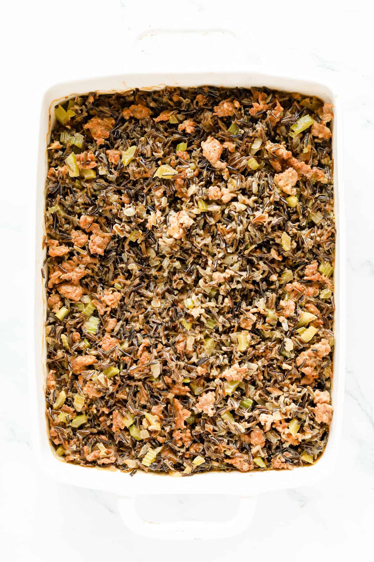 Baked wild rice hot dish in a white baking dish.