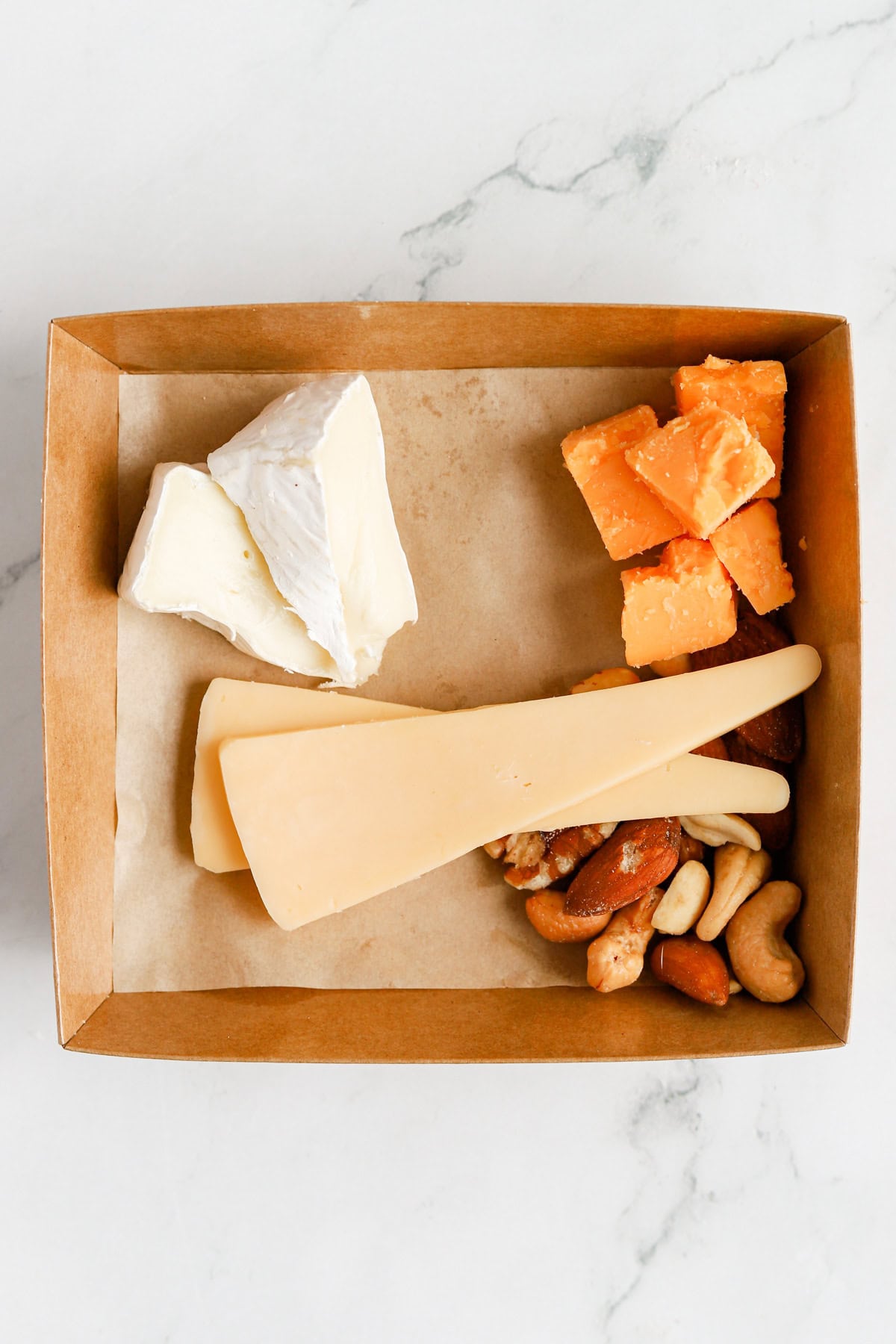 Three cheeses added to the box with mixed nuts