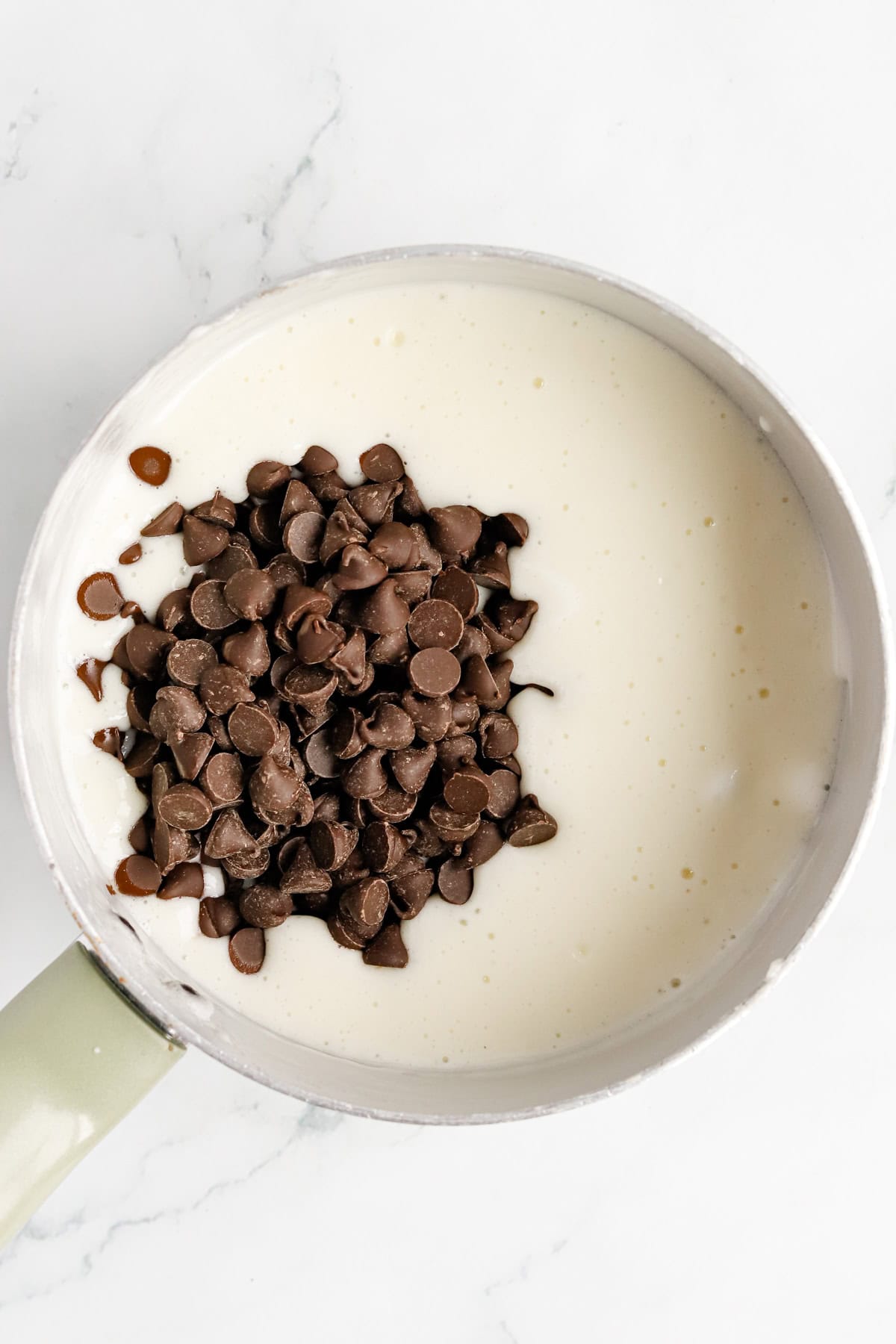 Chocolate chips in a saucepan of melted marshmallows, milk and butter