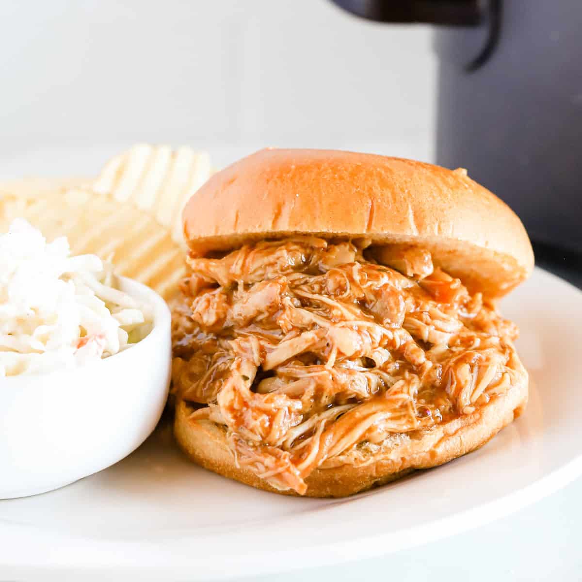 Featured image of bbq pulled chicken sandwich on a white plate