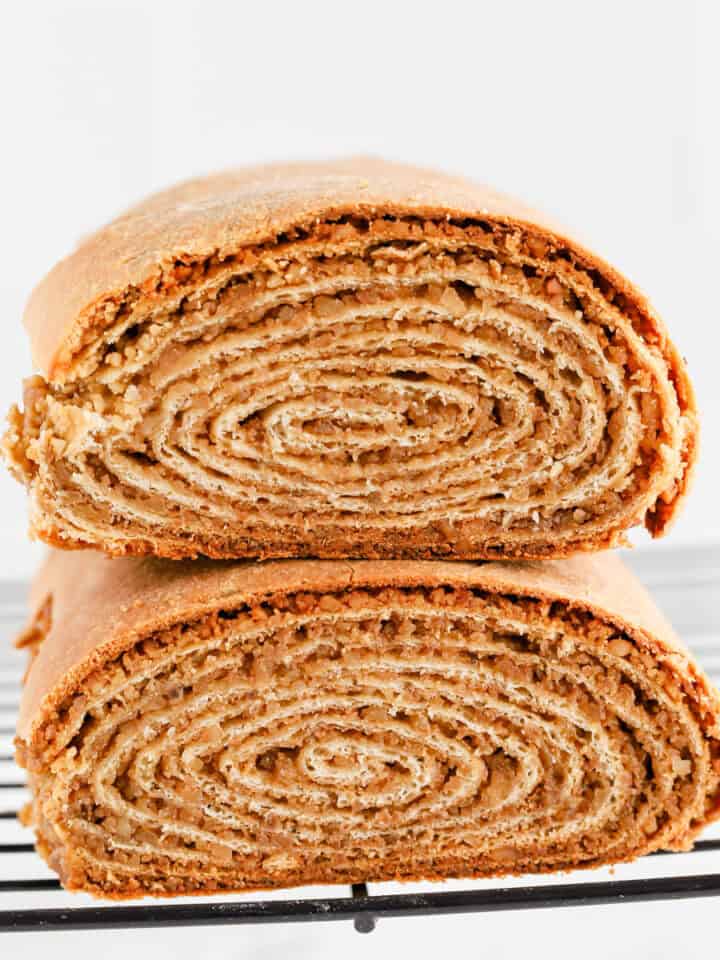 Potica loaves stacked on top of each other on wire rack revealing spiral center.
