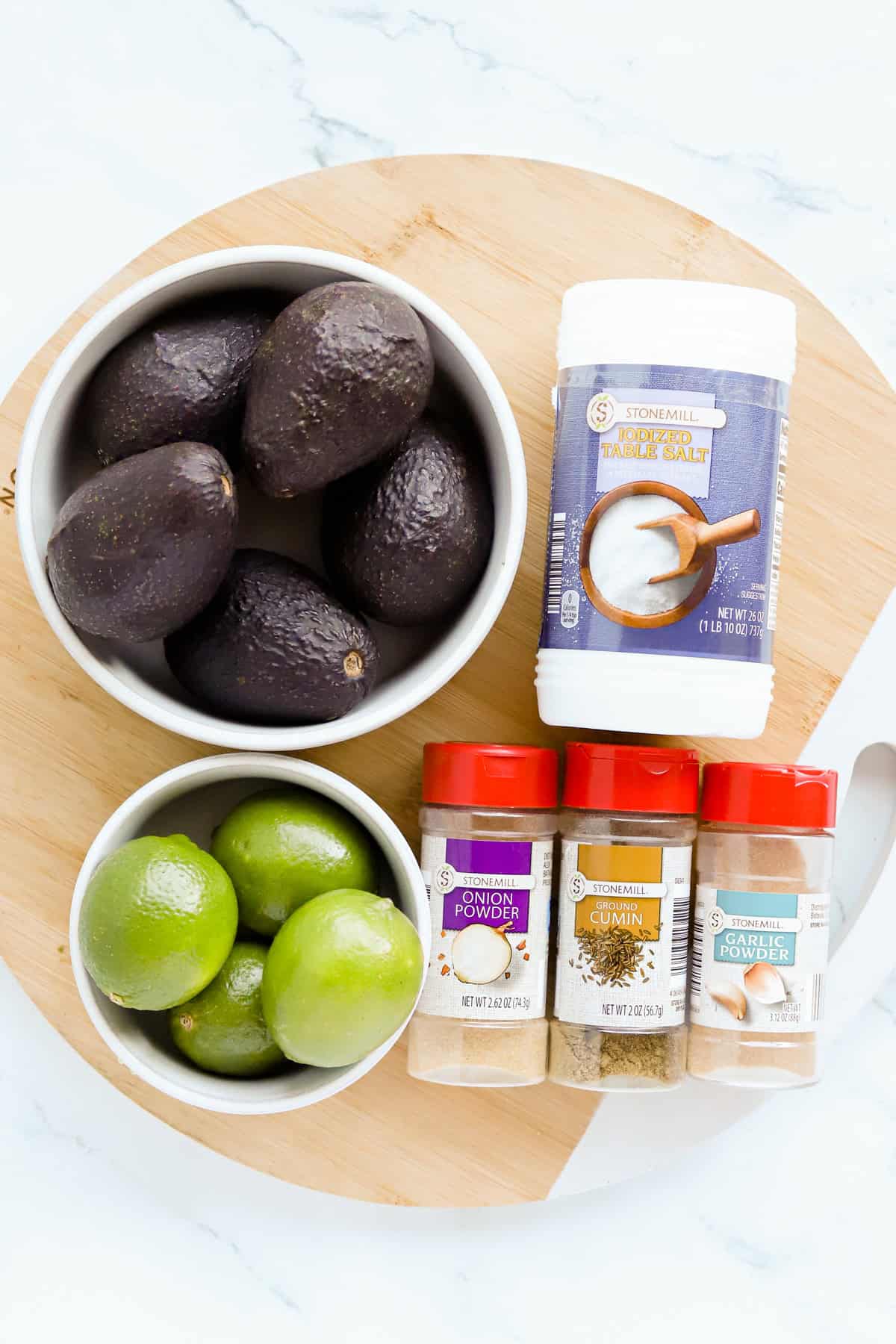 Guacamole ingredients on a round wooden tray