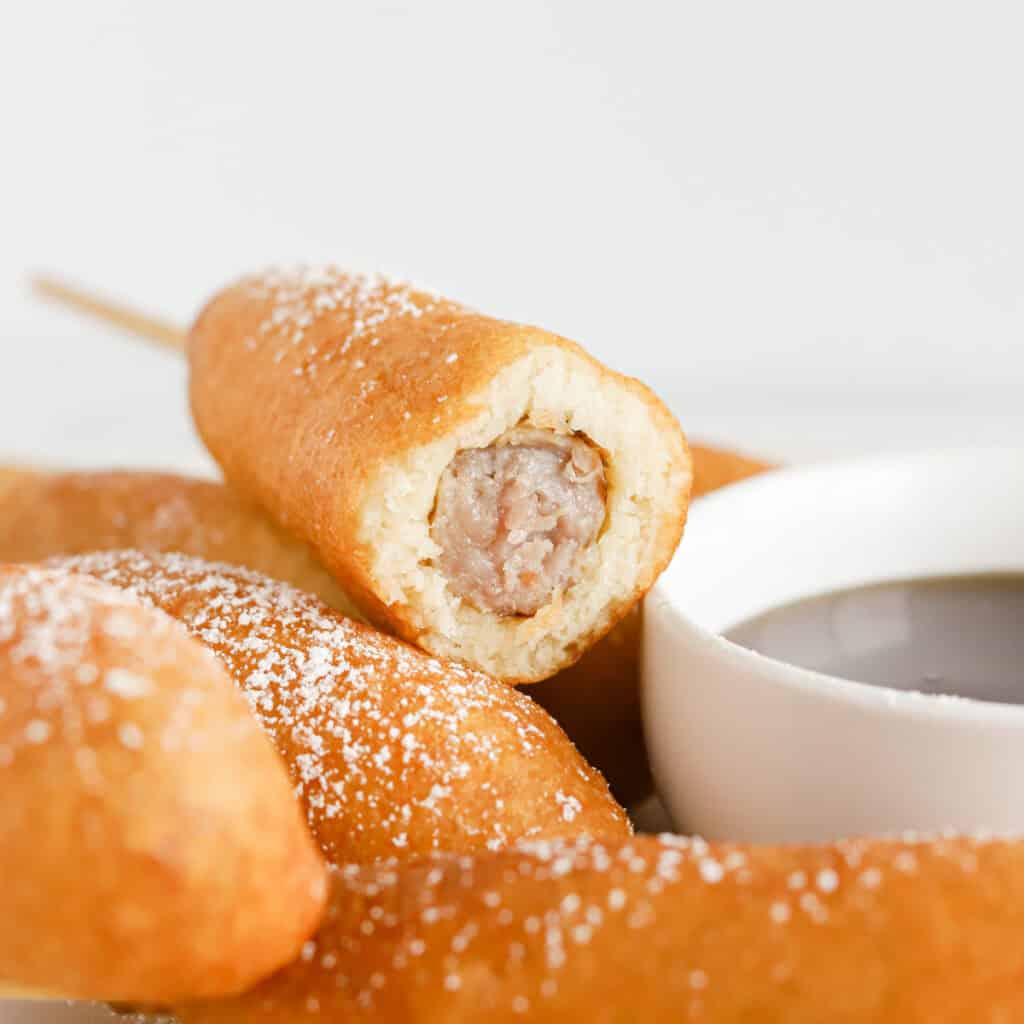 Inside view of breakfast corn dog with sausage link in the middle