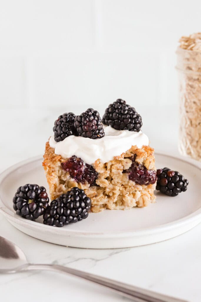 Plated blackberry oatmeal with a dollop of greek yogurt and more berries on top.