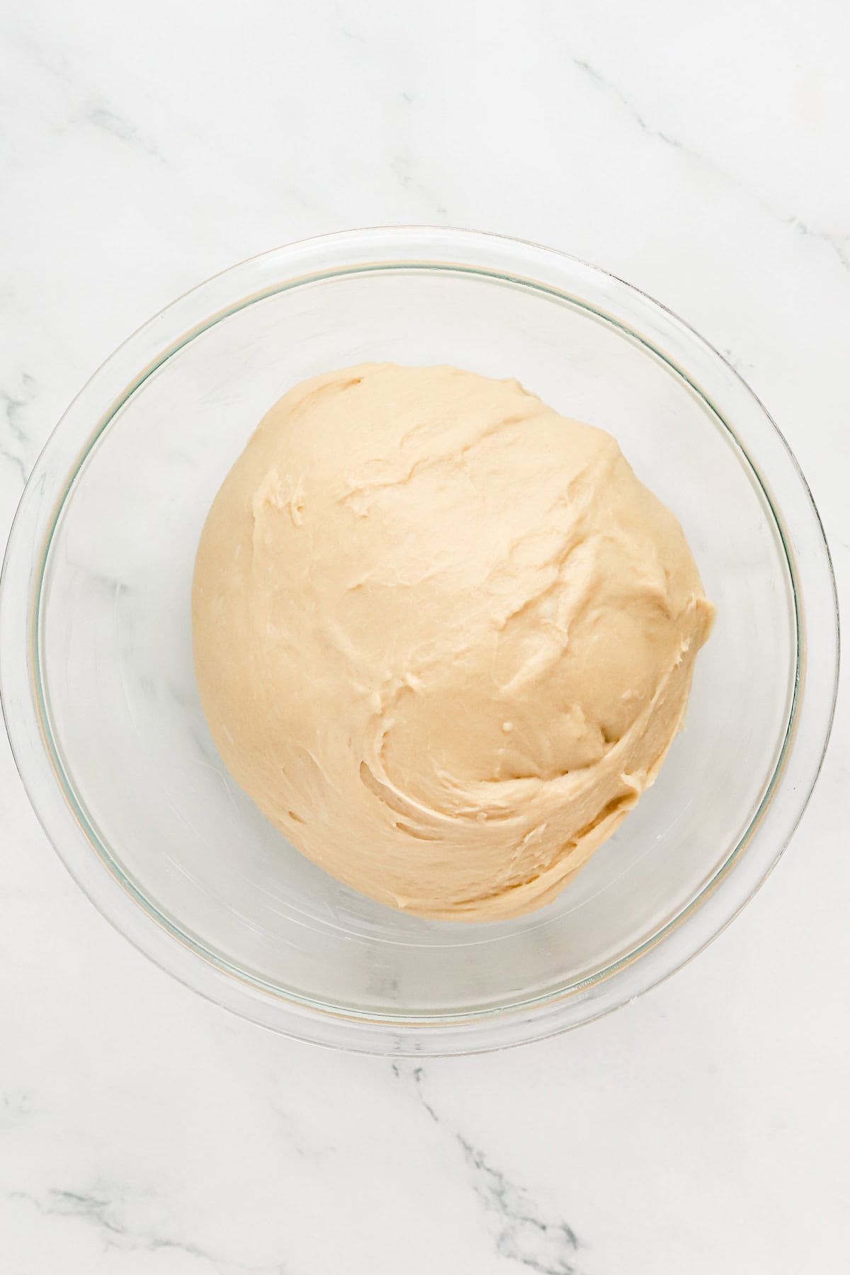 Yeast dough in a glass bowl.
