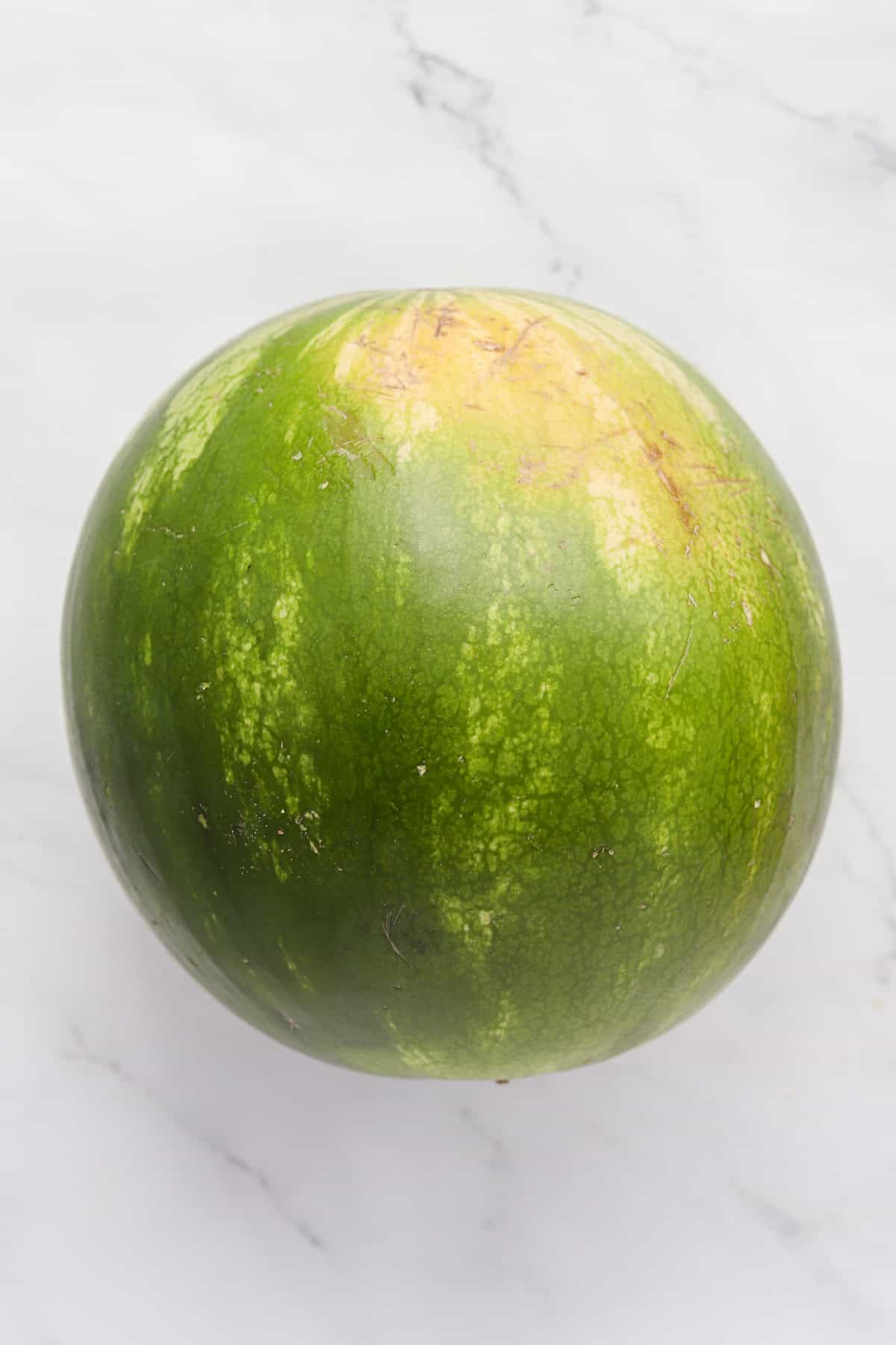 Whole round watermelon on counter.