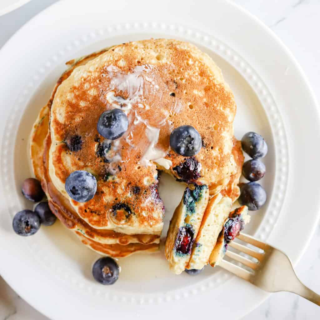 Plated blueberry pancakes with fresh blueberries