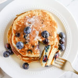 Plated blueberry pancakes with fresh blueberries