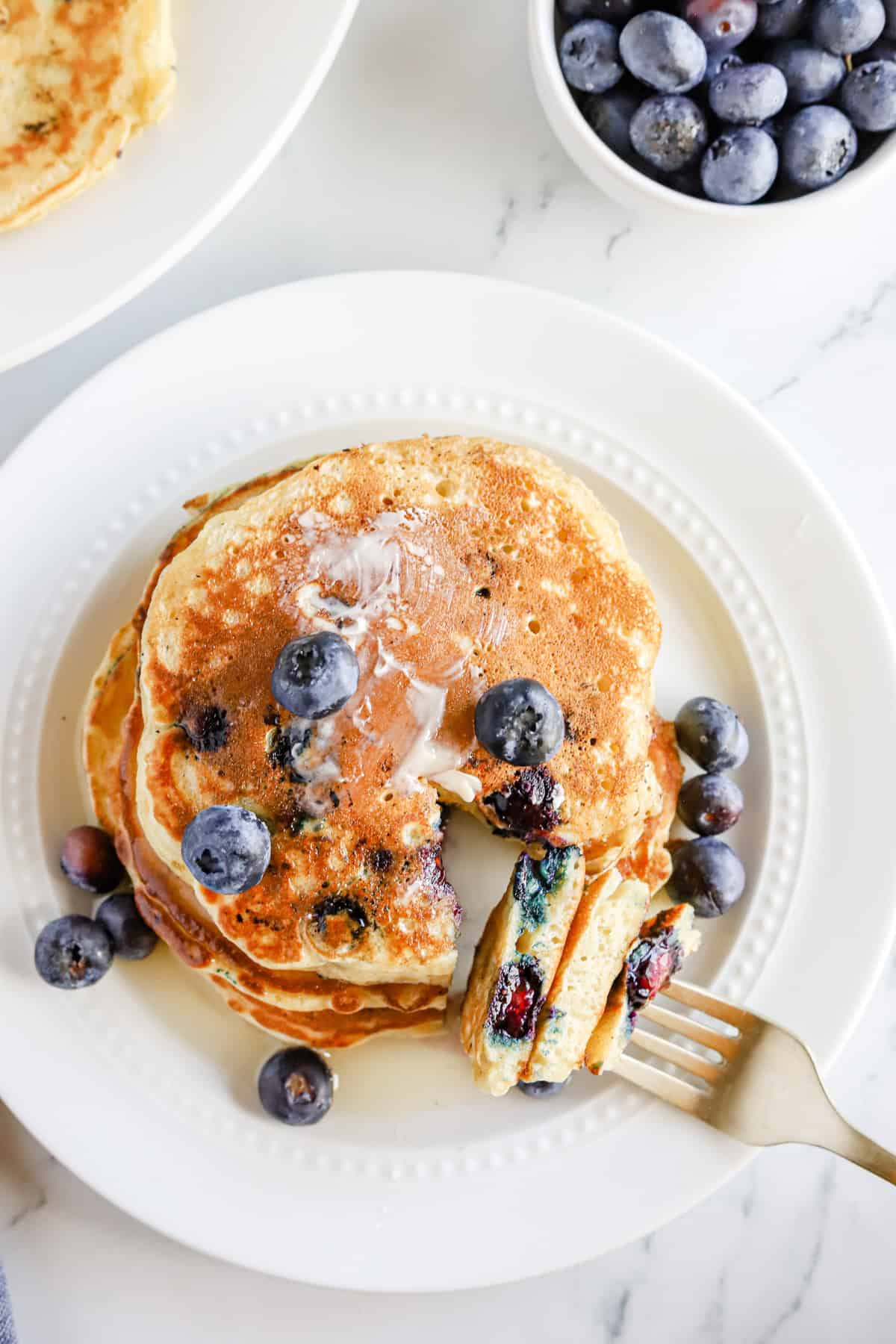 Plated blueberry pancakes with fresh blueberries