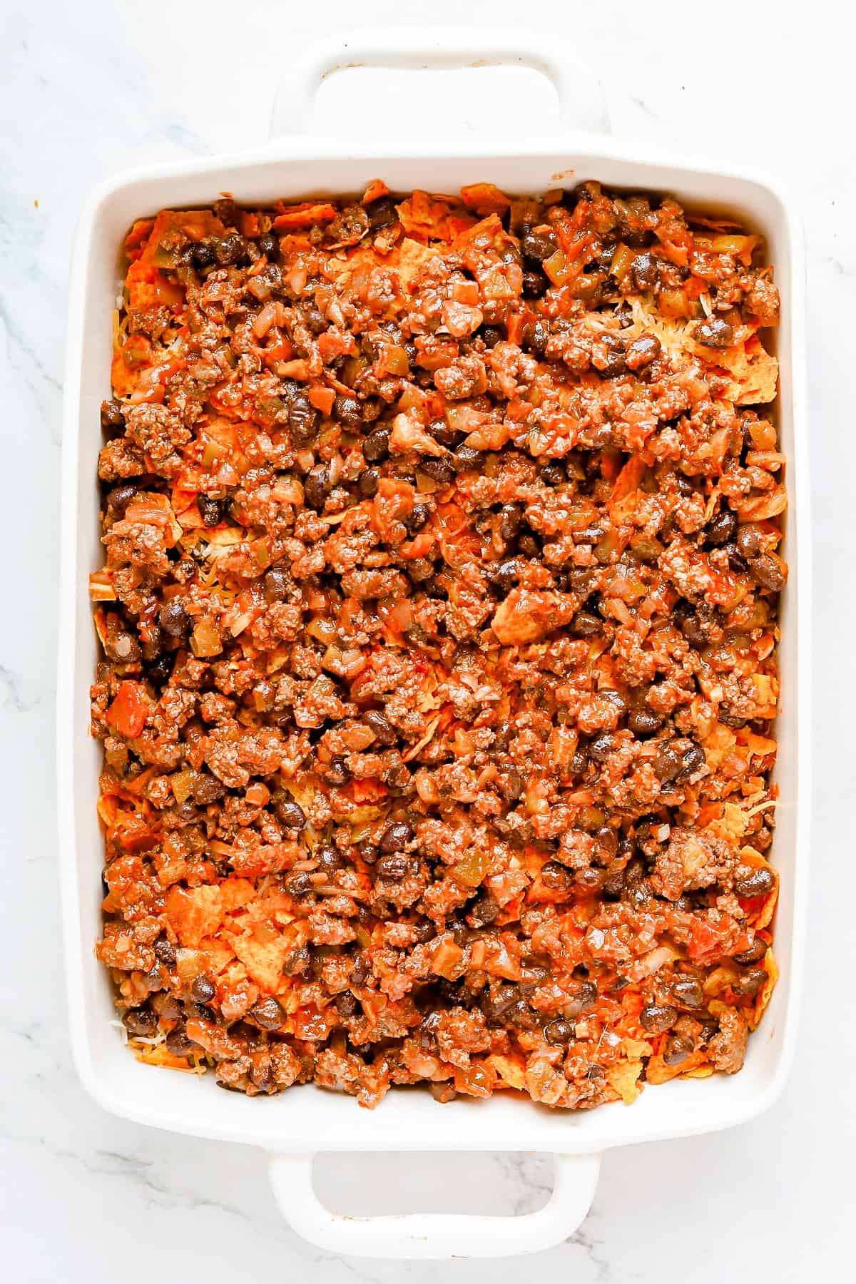 Second layer of seasoned meat on casserole.