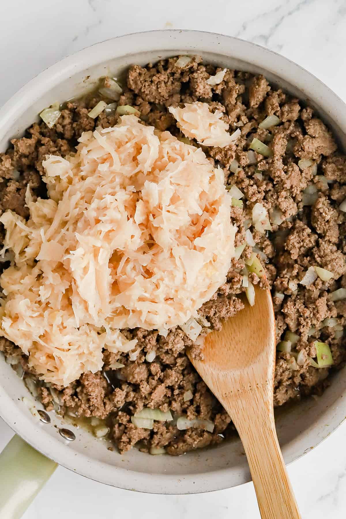 Sauerkraut added to skillet of ground beef, celery and onion.