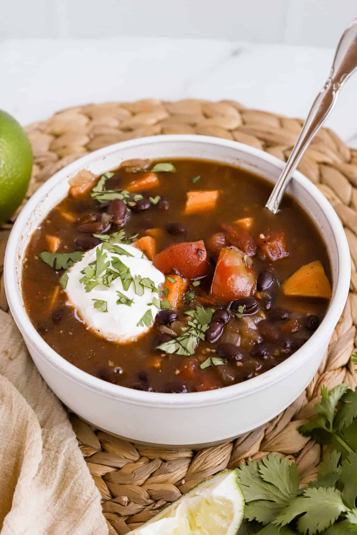 Square photo of bowl of soup garnished with sour cream and chopped cilantro.