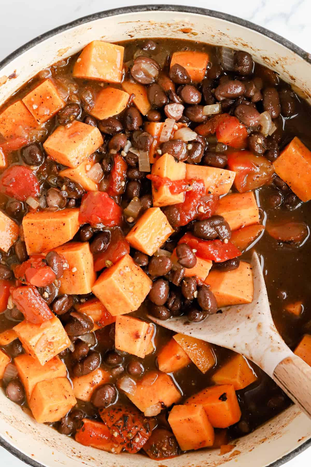 Sweet potatoes, tomatoes and beans in a Dutch oven.