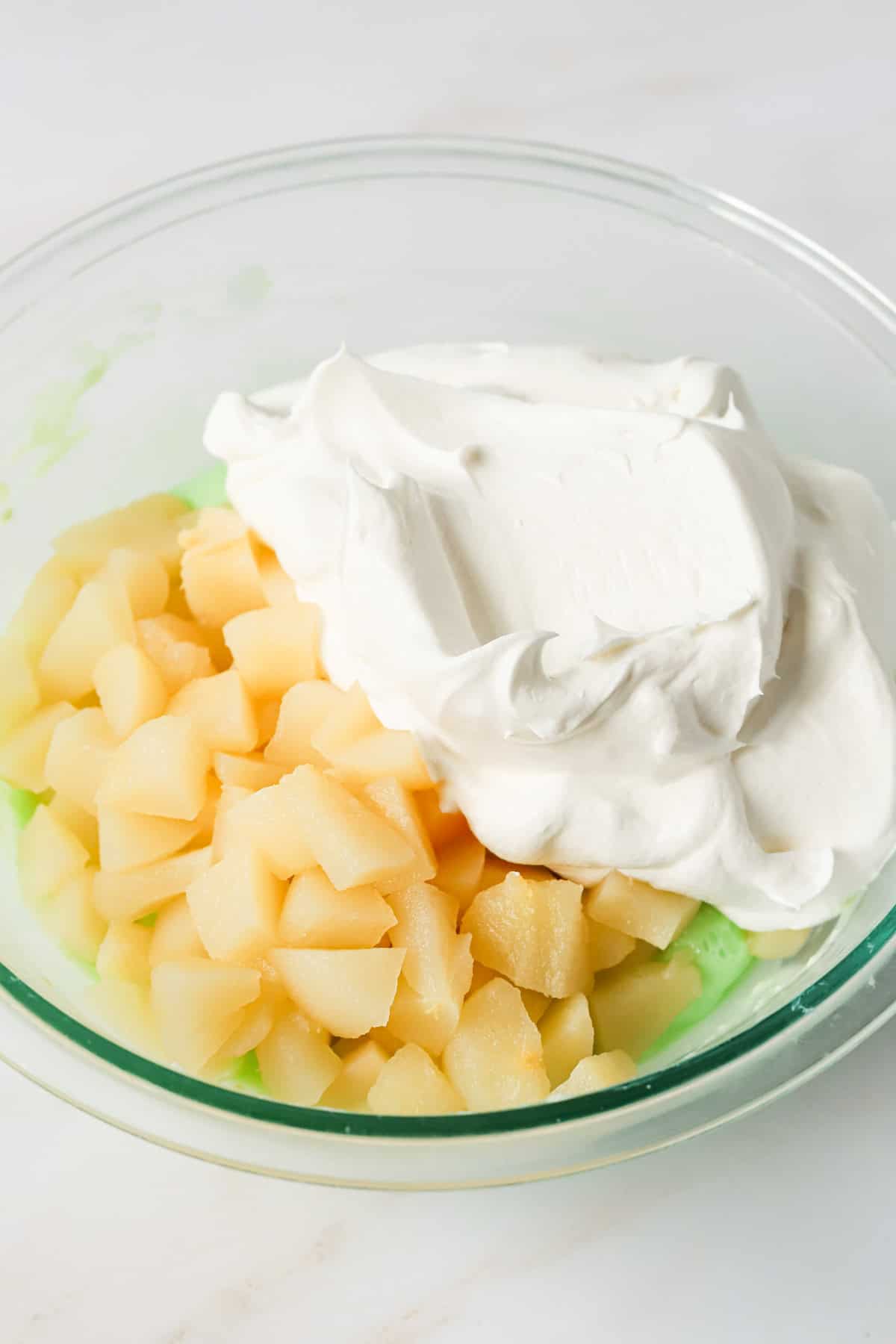 Diced pears and whipped topping added to the bowl of cream cheese and lime jello.