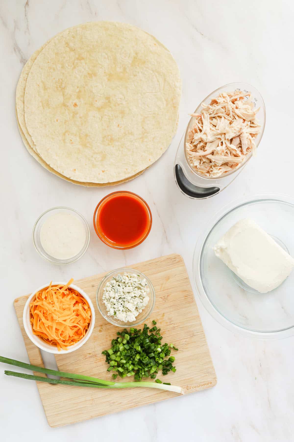 Buffalo chicken pinwheel ingredients laid out on countertop.